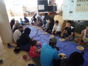 Eine Gruppe von Flüchtlingen beim Mittagessen in Habibi.Works