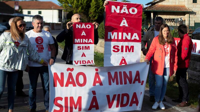 Sieben Menschen halten Schilder und ein Transparent mit der Aufschrift: "Nein zu den Minen, ja zum Leben!" auf Portugiesisch