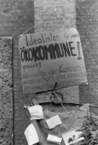 Pappe mit Schriftzug: Idealisten für unser Ökokomune gesucht! Wir wollen der Konsumgesellschaft eine sinnvolee Alternative vorleben.
